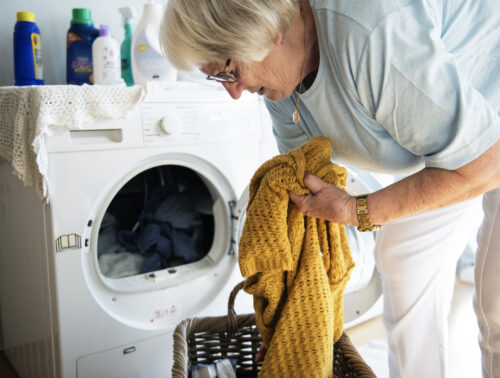 Elderly woman doing a laundry