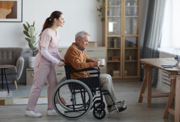 Female Caregiver Assisting Senior Man in Wheelchair